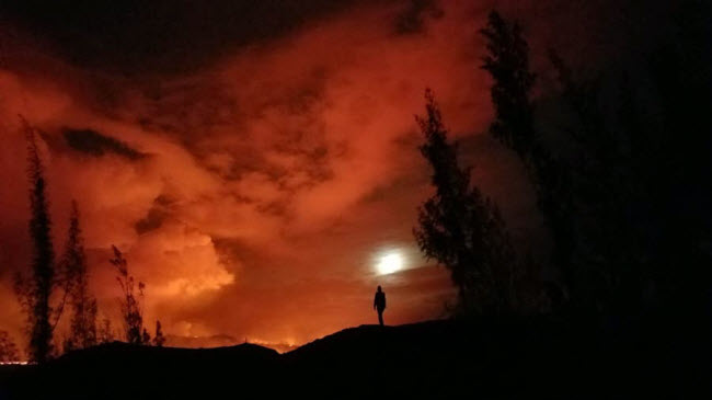 Du khách chiêm ngưỡng cảnh dung nham đỏ rực phun trào lên từ núi lửa Kilauea tại quần đảo Hawaii, Mỹ.