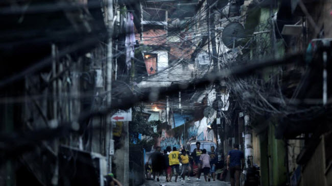 Mọi người chơi đá bóng trên đường tại Rocinha, khu ổ chuột lớn nhất ở thành phố Rio de Janeiro, Brazil.