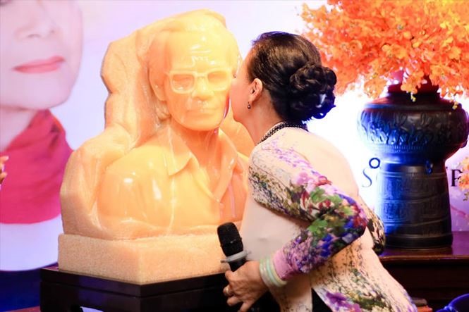 Khánh Ly hôn lên má tượng Trịnh Công Sơn tạc bằng đá onyx xuyên sáng do người hâm mộ tặng.