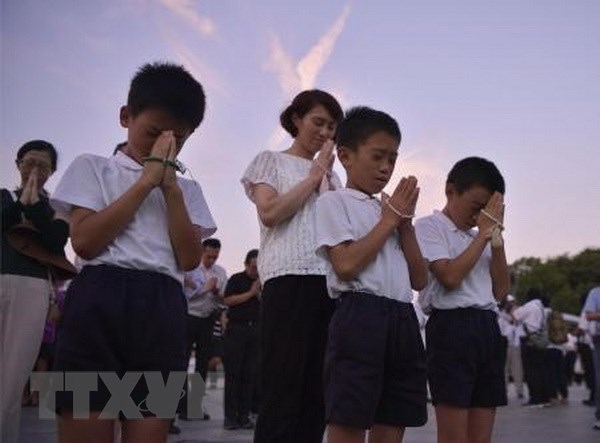 Trẻ em Nhật Bản cầu nguyện cho các nạn nhân bom nguyên tử tại Công viên Hòa bình ở Hiroshima. (Nguồn: Kyodo/TTXVN)