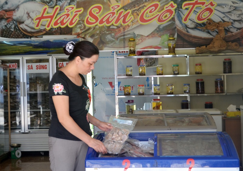 Bà Bùi Thị Oanh, kiểm tra sản phẩm thủy sản được bày bán tại Trung tâm giới thiệu sản phẩm thủy sản Cô Tô.