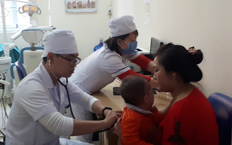 Bác sĩ  đang khám bệnh cho bệnh nhân trẻ em tại Trung tâm y tế huyện Hoành Bồ.