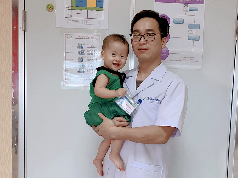 Anh Nguyễn Đức Thuận bế trên tay cháu bé được sinh ra bằng phương pháp thụ tinh trong ống nghiệm.