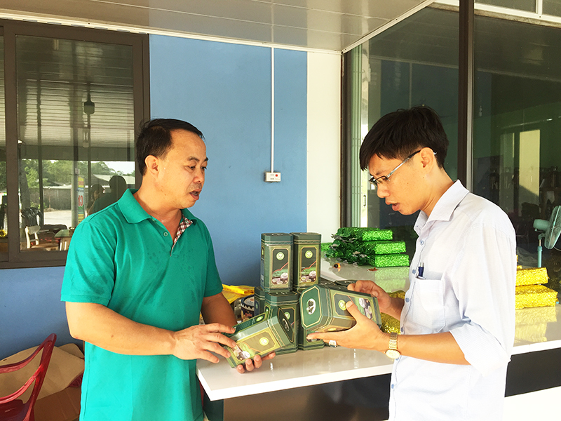 Ông Trần Sĩ Dũng (bên phải), chủ cơ sở sản xuất chè Dũng Nga, xã Quảng Long, huyện Hải Hà giới thiệu về sản phẩm chè của địa phương.