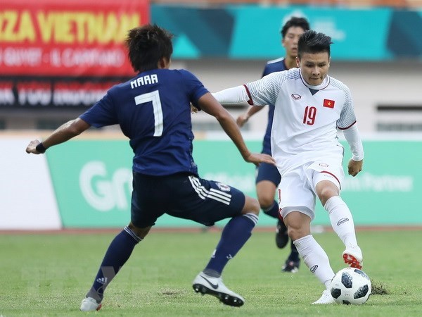 Tiền vệ Quang Hải (áo số 19) trong một pha tranh bóng với cầu thủ đội tuyển Olympic Nhật Bản. (Ảnh: Hoàng Linh/TTXVN)