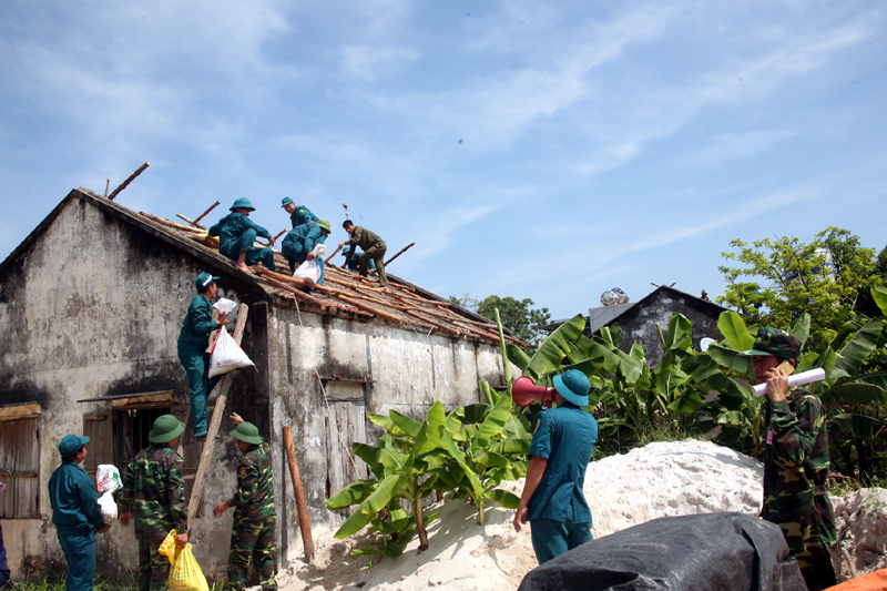 Lực lượng vũ trang huyện Vân Đồn hành quân dã ngoại giúp nhân dân sửa chữa nhà ở xã Quan Lạn. Ảnh: Bùi Đình Phong (Ban CHQS huyện Vân Đồn) 