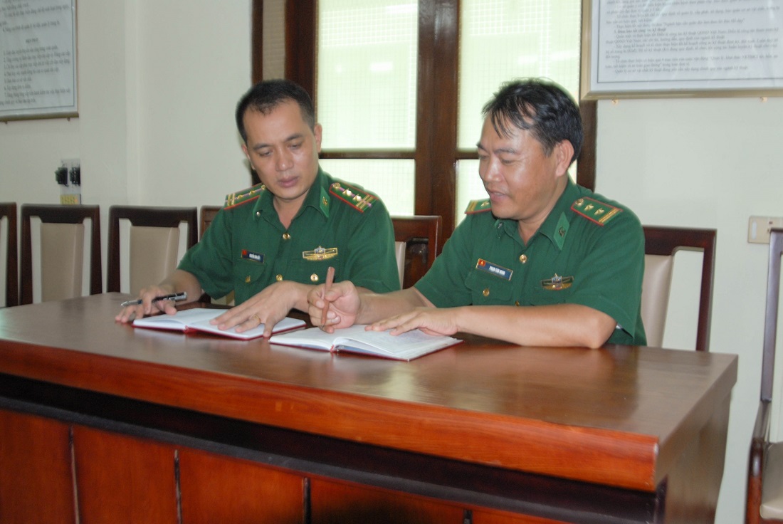 Trung tá Nguyễn Văn Bảy (bên trái) trao đổi công việc với lãnh đạo Ban Cơ yếu (Phòng Tham mưu, Bộ Chỉ huy BĐBP tỉnh).