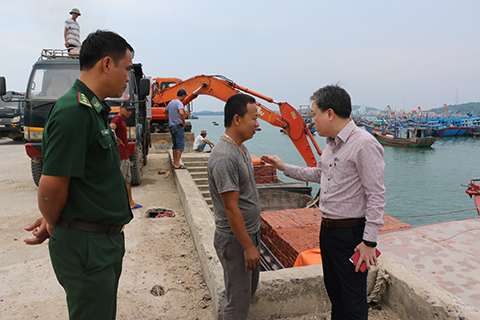 Đồng chí Lê Hồng Giang - Phó Chủ tịch UBND huyện (phải) vận động chủ phương tiện di dời tàu thuyền, đảm bảo tuyệt đối an toàn.