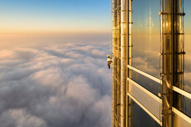 Công nhân lau cửa sổ kính bên ngoài tầng 124 của tòa nhà cao nhất thế giới Burj Khalifa ở thành phố Dubai.