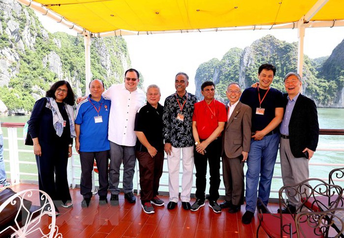 Các đại biểu chụp ảnh kỷ niệm trên tàu đi tham quan Vịnh Hạ Long. (Ảnh: TTXVN)