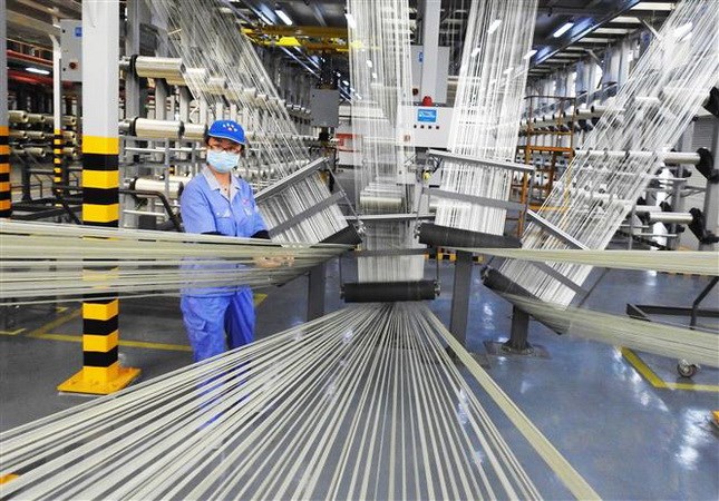 Công nhân làm việc tại nhà máy sản xuất sợi cacbon ở tỉnh Giang Tô của Trung Quốc ngày 9/8. (Ảnh: AFP/TTXVN)