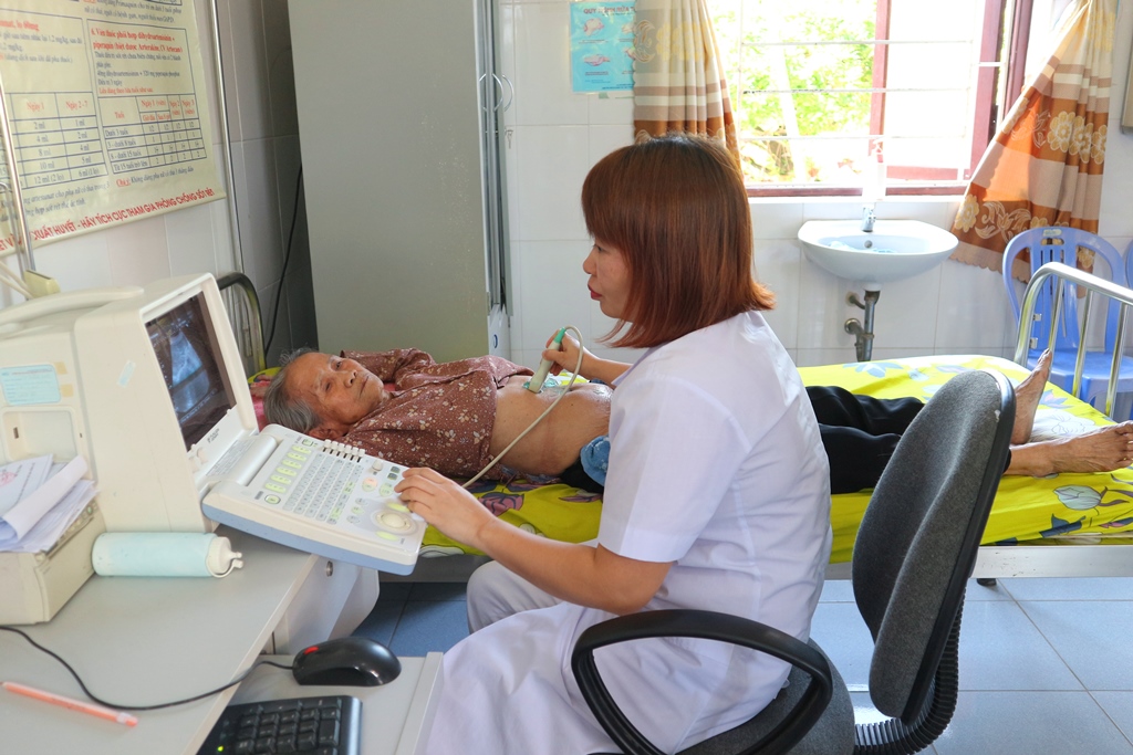 Chị Đỗ Thị Thảo, Trạm trưởng trạm y tế phường Phương Nam tiến hành siêu âm ổ bụng cho bệnh nhân