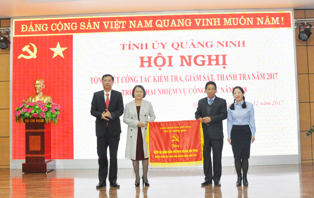 Đồng chí Nguyễn Văn Đọc, Bí thư Tỉnh ủy, Chủ tịch HĐND tỉnh, trao cờ đơn vị dẫn đầu phong trào thi đua năm 2017 cho Ủy ban Kiểm tra huyện ủy Tiên Yên.