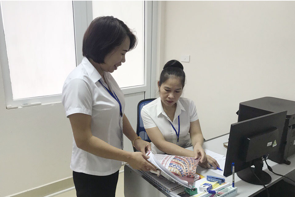 Cán bộ Phòng Dân số, Trung tâm Y tế TX Quảng Yên trao đổi công việc.