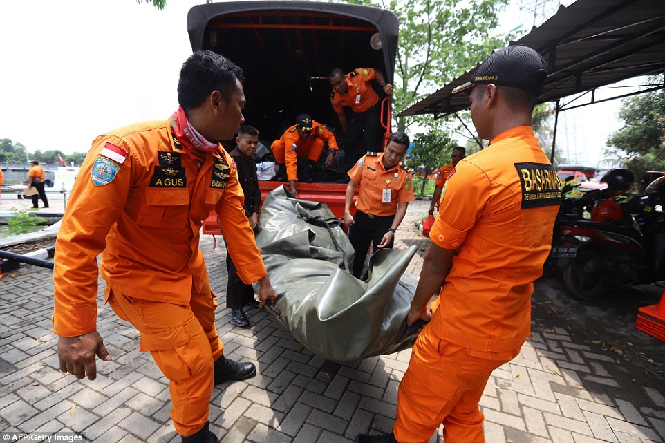 Lực lượng cứu hộ khiêng vật được cho là một túi đựng xác. Ảnh: AFP