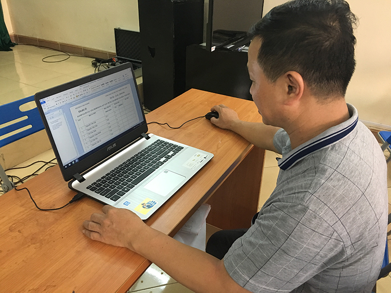 Bí thư Chi bộ, trưởng khu phố 2B, phường Cẩm Thành, TP Cẩm Phả sử dụng máy tính có kết nối internet cập nhật văn bản của phường để tuyên truyền cho nhân dân.