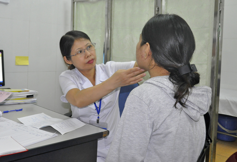 Bác sĩ Hà Thị Quế, Trưởng Khoa Da liễu và Phòng chống mù lòa, Trung tâm Kiểm soát bệnh tật Quảng Ninh kiểm tra da cho bệnh nhân bị dị ứng mỹ phẩm.