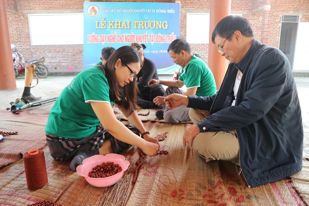 Chị Nguyễn Hải Yến, Chủ nhiệm CLB NKT TX Đông Triều hướng dẫn làm đồ thủ công mỹ nghệ từ xâu hạt gỗ cho các thành viên trong CLB