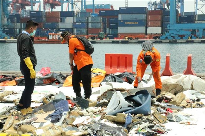 Các nhân viên của Cơ quan Tìm kiếm cứu nạn quốc gia Indonesia đang tìm những vật dụng phục vụ phân tích vụ việc. (Ảnh: Đỗ Quyên/TTXVN)