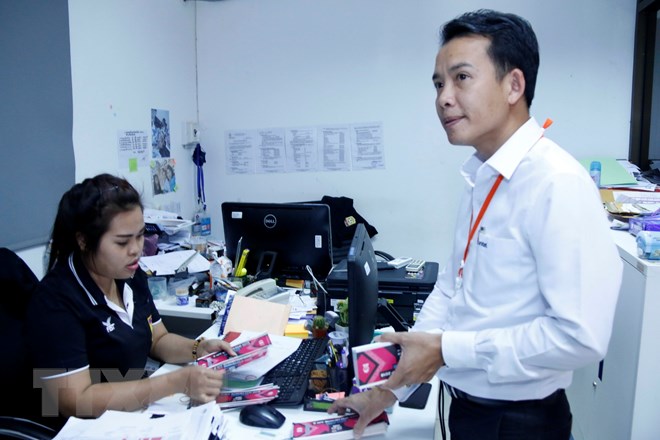 Nhân viên của Công ty Unitel, liên doanh Viễn thông giữa giữa Viettel và Lao Asia Telecom mua hàng trăm vé cho các cán bộ công nhân của Công ty tại Liên đoàn Bóng đá Lào. (Ảnh: Phạm Kiên/TTXVN)