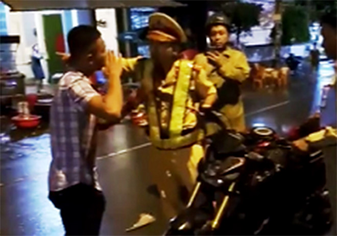 Cảnh sát giao thông (Công an TP Quy Nhơn) tranh cãi với thanh niên. Ảnh cắt từ clip.