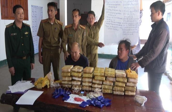 Các đối tượng và tang vật bắt giữ trong chuyên án tại cơ quan Ty an ninh Oudomxay, Lào. Ảnh: TTXVN phát