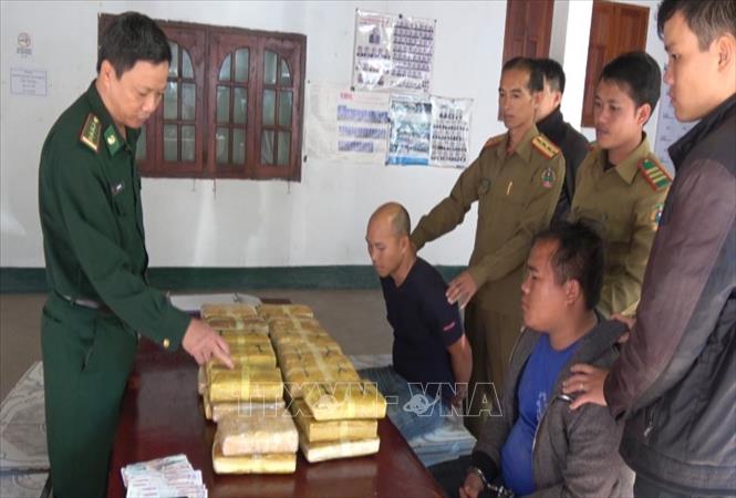 Các đối tượng và tang vật bắt giữ trong chuyên án tại cơ quan Ty an ninh Oudomxay, Lào. Ảnh: TTXVN phát