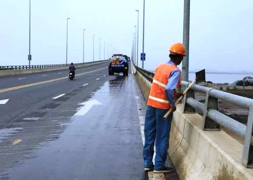 Công nhân dọn vệ sinh đảm bảo cho người và xe qua cầu an toàn. Ảnh: CTV
