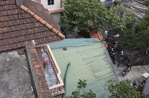 Mái nhà tôn màu xanh nơi Hà ném đứa bé lăn xuống đất. Ảnh: Nguyễn Hải.