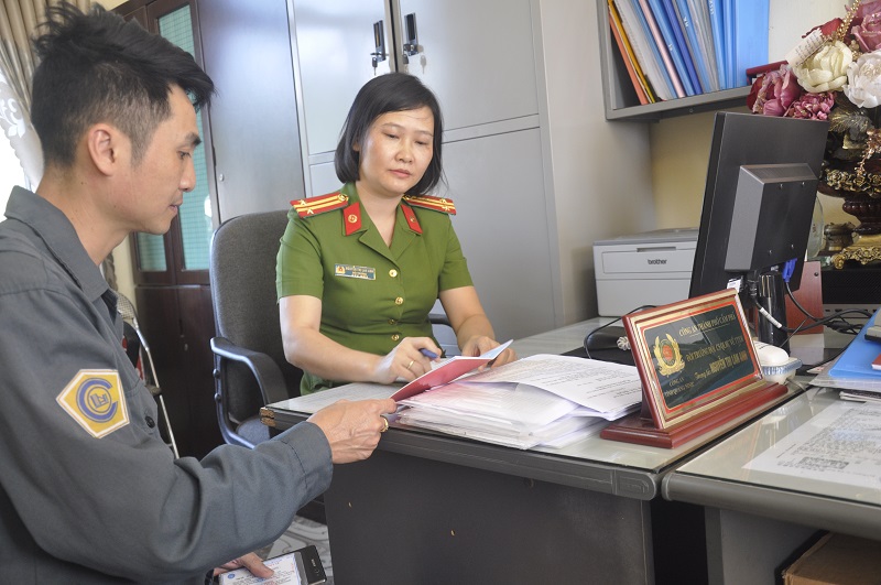 Trung tá Nguyễn Thị Lan Anh tận tình hưỡng dẫn người dân thực hiện  thủ tục cấp đổi hộ khẩu.