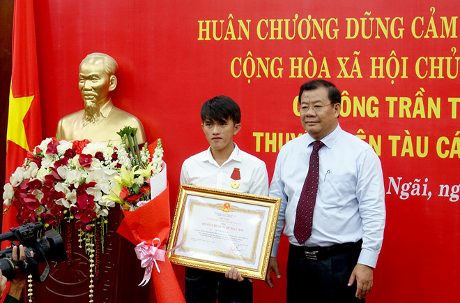 Phó chủ tịch UBND tỉnh Quảng Ngãi Nguyễn Tăng Bính trao Huân chương Dũng cảm cho ngư dân Trần Thanh Ron. Ảnh: Minh Hoàng.