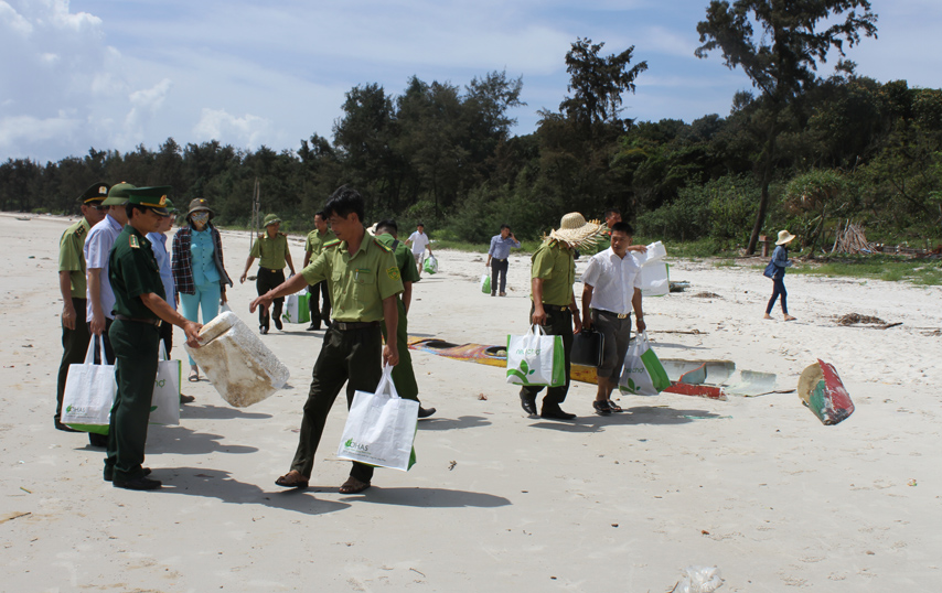 Lực lượng chức năng, du khách và người dân xã Minh Châu (huyện Vân Đồn) dọn rác làm sạch bãi tắm.
