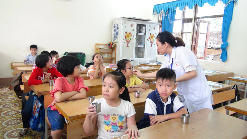 Cán bộ Y tế cho trẻ uống thuốc tẩy giun tại Trường Tiểu học Hạ Long (TP Hạ Long).