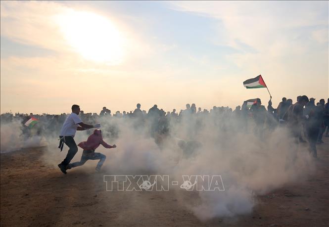 Người biểu tình Palestine chạy trốn đạn hơi cay trong cuộc xung đột với binh sĩ Israel tại thành phố biên giới Khan Yunis, phía nam Dải Gaza ngày 9/11/2018. Ảnh: AFP/TTXVN
