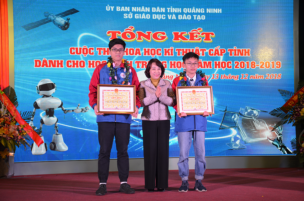 Đồng chí Vũ Thị Thu Thủy, Phó Chủ tịch UBND tỉnh tặng bằng khen của UBND tỉnh cho hai học sinh Trường THPT Chuyên Hạ Long.