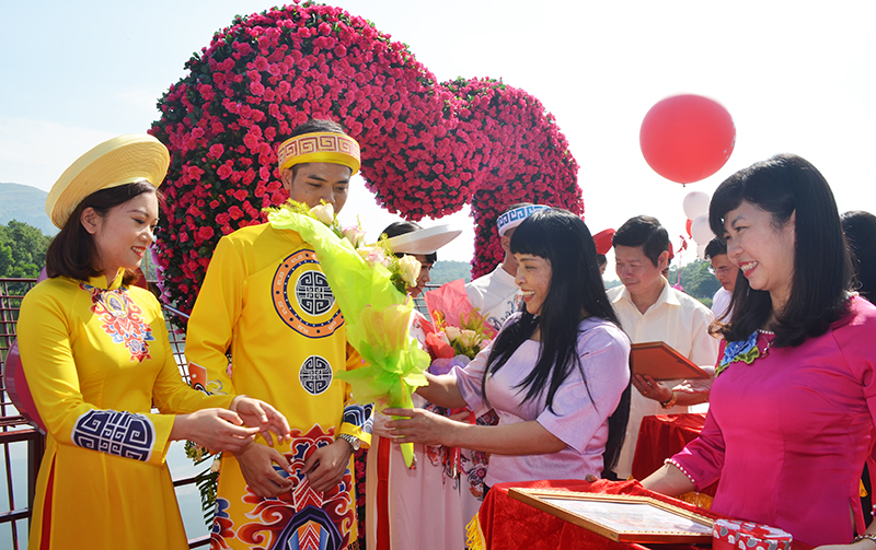 Phó Bí thư Thành ủy Hoàng Thị Hà tặng hoa kỷ niệm các đôi uyên ương đầu tiên móc khóa tại cầu tình yêu hồ Yên Trung