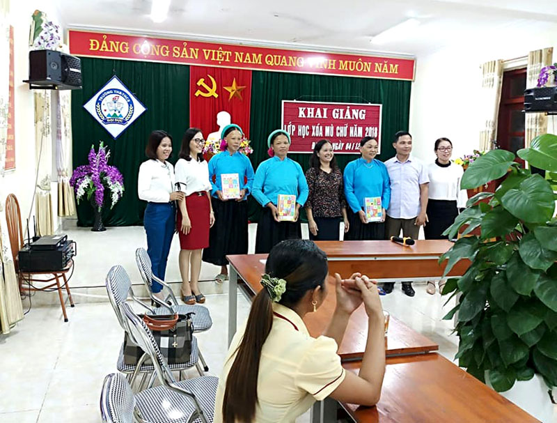 Cán bộ Hội LHPN huyện Tiên Yên tặng sách vở cho các học viên lớp xóa mù chữ ở Đại Dực (Ảnh của Hội LHPN huyện Tiên Yên)