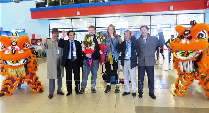 Đại diện lãnh đạo ngành du lịch Quảng Bình và công ty lữ hành, doanh nghiệp kinh doanh dịch vụ du lịch trên địa bàn tỉnh Quảng Bình đón và tặng hoa cho các du khách quốc tế đầu tiên trong ngày đầu năm mới. Ảnh: Võ Dung/TTXVN