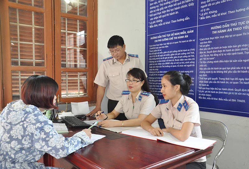 Cán bộ Bộ phận một cửa tiếp nhận và trả kết quả của Chi cục THADS huyện Hoành Bồ hướng dẫn công dân giải quyết TTHC trong lĩnh vực THADS.