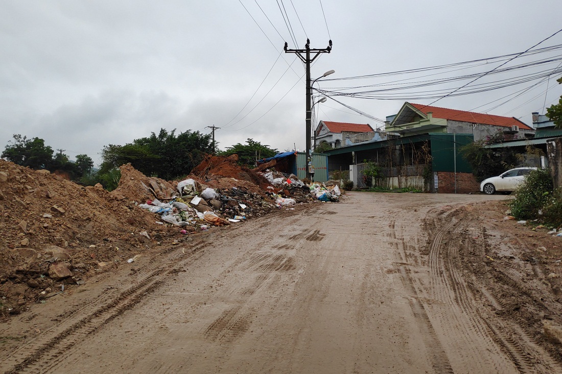 Rác thải sinh hoạt bị đổ trộm tràn ra đường đi tại rìa moong khai thác sét ở khu 5, phường Giếng Đáy.