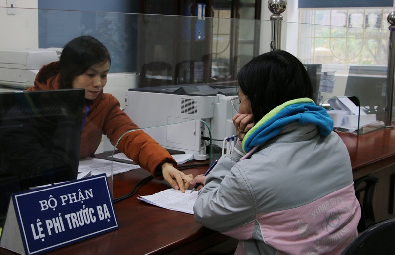 Cán bộ thuế hướng dẫn người dân làm thủ tục tại Trung tâm HCC huyện Bình Liêu.