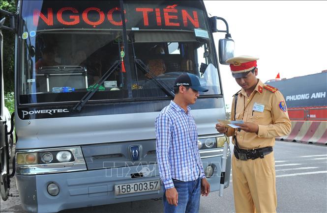 Lực lượng Cảnh sát giao thông kiểm tra giấy tờ xe trên tuyến QL1A. Ảnh: Minh Đức/TTXVN