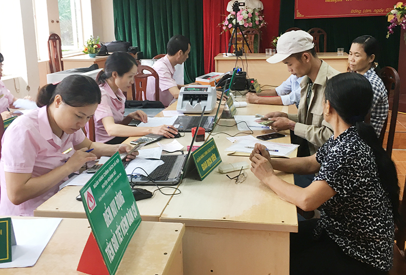 Cán bộ Ngân hàng CSXH huyện Hoành Bồ thực hiện giao dịch tại xã Đồng Lâm.