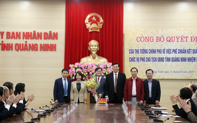 Các đồng chí lãnh đạo UBND tỉnh tặng hoa chúc mừng đồng chí Bùi Văn Khắng. 