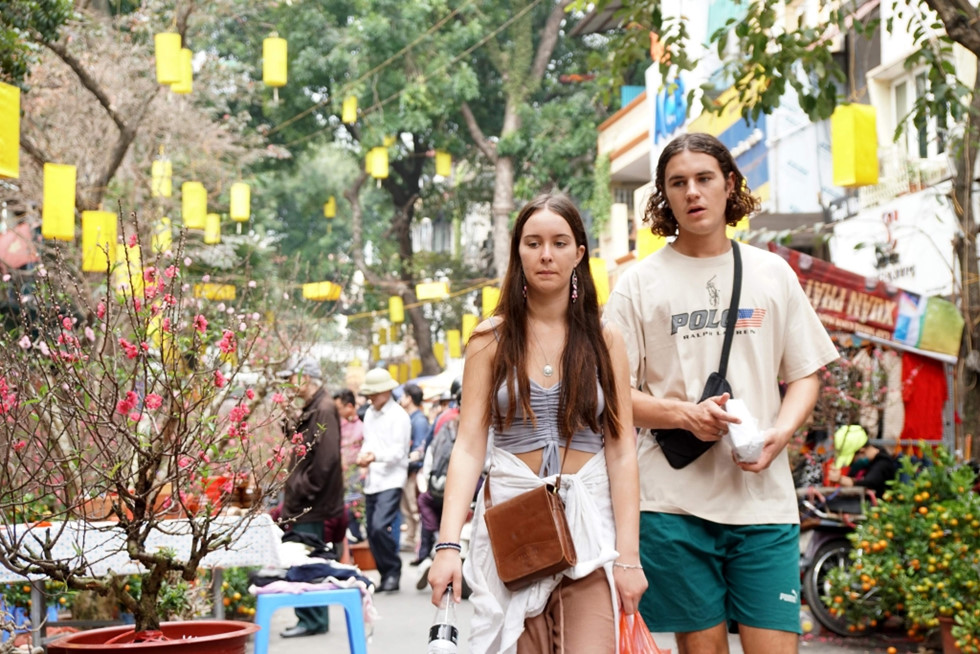 Không chỉ thu hút người dân thủ đô, chợ hoa Hàng Lược còn là điểm đến được nhiều du khách nước ngoài lựa chọn để khám phá cuộc sống của Hà Nội mỗi dịp xuân về. Ảnh Gia Hân
