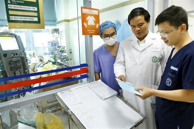 Các bác sỹ hội chẩn cho bệnh nhân mắc cúm A/H1N1. (Ảnh: Dương Ngọc/TTXVN)