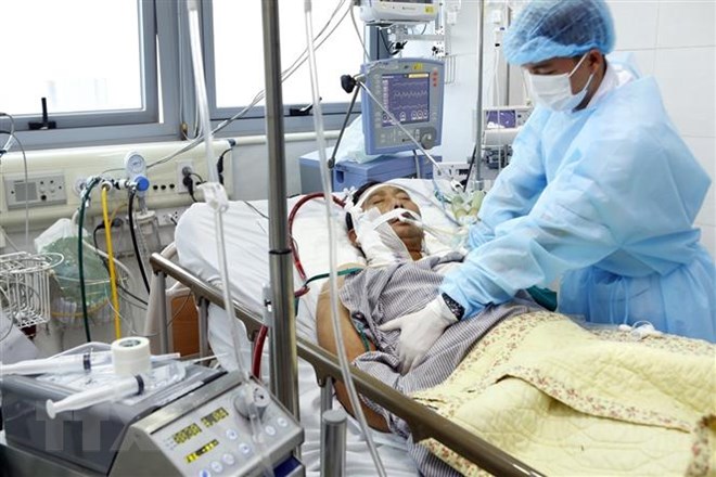 Các bác sỹ Bệnh viện Bạch Mai điều trị cho bệnh nhân 51 tuổi mắc cúm A/H1N1. (Ảnh: Dương Ngọc/TTXVN)