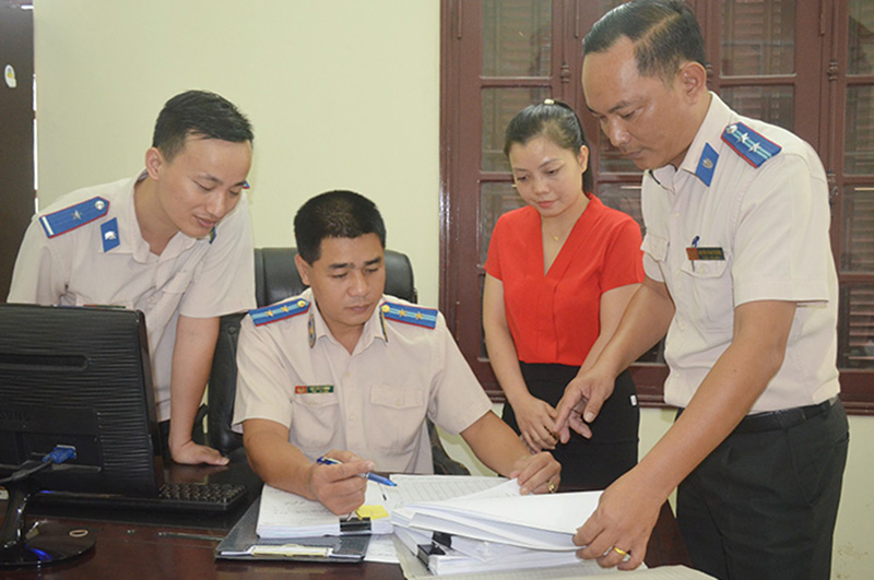 Cán bộ Chi cục THADS TP Cẩm Phả trao đổi biện pháp triển khai công tác thi hành án. Ảnh: Nguyễn Chiến