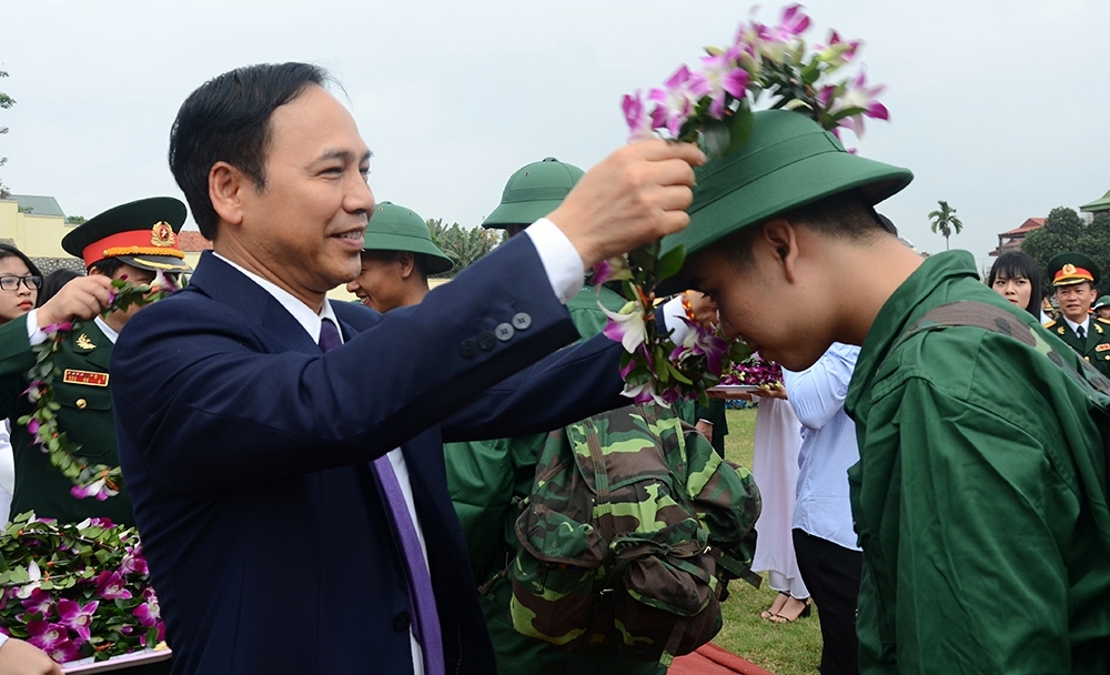 Đồng chí Phó Chủ tịch Thường trực UBND tỉnh Đặng Huy Hậu tặng hoa chúc mwungf và động viên tân binh lên đường nhập ngũ tmanhj khỏe, tiến bộ