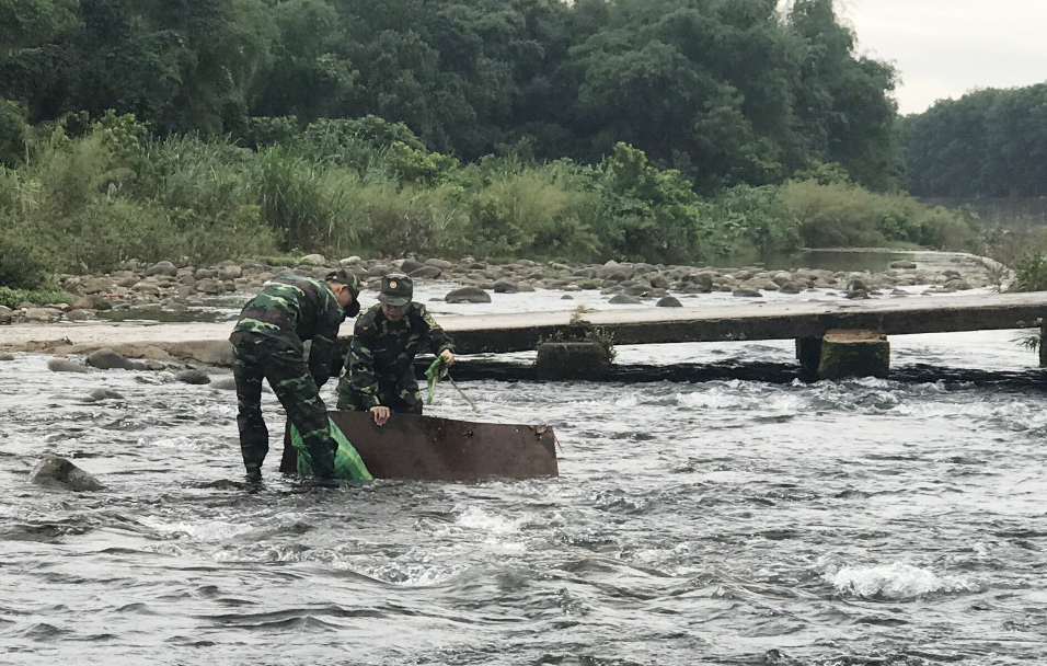 Chiến sĩ Đồn Biên phòng Pò Hèn dọn rác trên sông biên giới.